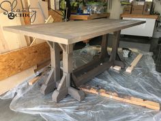 a wooden table sitting on top of a plastic covered floor