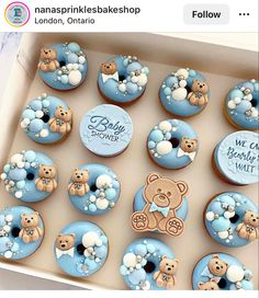 a box filled with lots of blue cupcakes covered in frosting and teddy bears