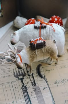 two stuffed animals with bows tied to them on top of a piece of paper mache