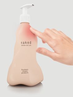 a hand holding onto a bottle of naked lotion