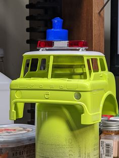 a toy firetruck sitting on top of a table next to jars and cans