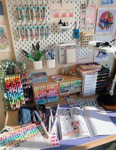 a desk with many different colored pencils and pens on it, along with other art supplies