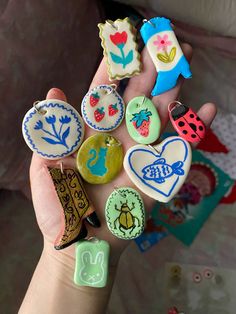 a person is holding many different buttons in their hand, including ladybugs and ladybug