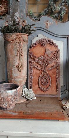 two vases sitting on top of a table next to a mirror and other items