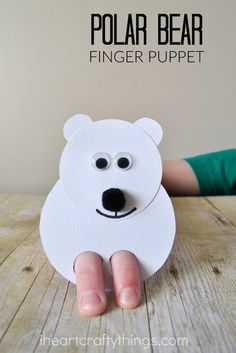 a polar bear finger puppet made out of paper on a wooden table with text overlay that reads, polar bear finger puppet