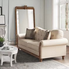 a living room filled with furniture and a large mirror