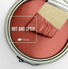 a red paint can with a brush in it and the words hot and spicy on it