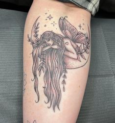 a woman's leg with a tattoo on it and an image of a mermaid