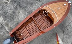 an overhead view of a wooden boat on the ground with no one in it,