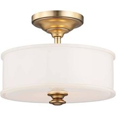 a light fixture with a white shade on the bottom and a gold finish to it