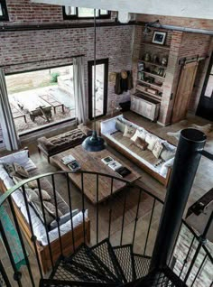 an aerial view of a living room and dining area from the second floor balcony looking down