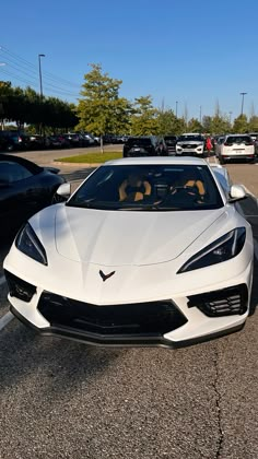 a white sports car parked in a parking lot