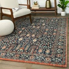 a living room area with a rug, chair and bookshelf