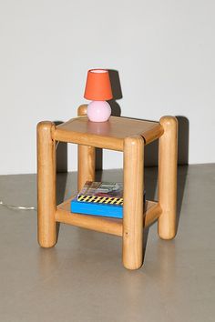 a small wooden table with a lamp on top