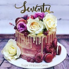 there is a cake with flowers on it and the words seventh written in gold lettering