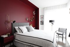 a bedroom with red walls and white bedding