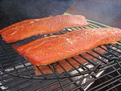 two salmons are cooking on the grill