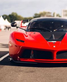 a red sports car driving down the road