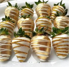 chocolate covered strawberries are arranged on a white platter with gold sprinkles