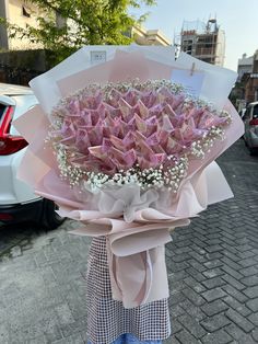 a person holding a bouquet of pink flowers