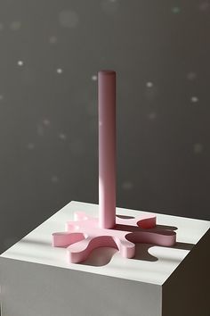 a pink candle sitting on top of a white block