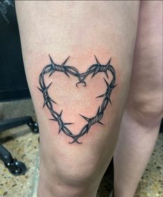 a heart shaped tattoo with barbed wire around it