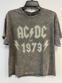 AC/DC est 1973 Oversize Crop - 100% Cotton Fabric - Adult Oversize Crop Tee  - Silver Colored Tee, Mineral Wash - Available in two sizes that fit most: S/M & L/XL - Fit: the length measurements are approximate due to the process applied to the garment. - Officially Licensed AC/DC Apparel **We sell this product as it is shown, we do not offer custom printing services for our t-shirts as all of them are pre-printed** Dirty Cotton Scoundrels accepts returns of unworn, undamaged merchandise within 30 days of purchase for a refund.  Sorry, no exchanges are offered due to stock constantly changing. Return Address is: Dirty Cotton Scoundrels 9400 Lurline Ave Suite F Chatsworth, CA 91311 PH: 818-883-2244 Customer Service Email: dirty@goodietwosleeves.com Acdc Tee, Rock Clothes, Spirit Days, Acdc Shirt, Back In Black, Rock Outfits, Rock Tees, School Clothes, Graphic Tees Vintage