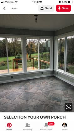 an empty room with large windows and stone flooring