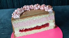 a piece of cake with pink and white frosting on it sitting on a plate