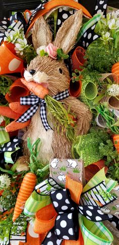 a close up of a wreath with a bunny on it and carrots in the middle