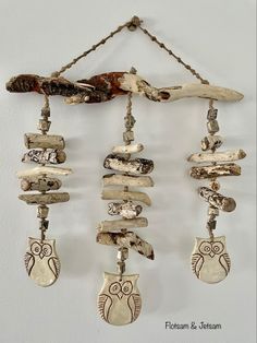 an owl is hanging from a chain with other items attached to it's sides