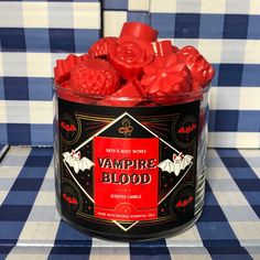 a can filled with vampire blood candy on top of a checkered tablecloth covered table