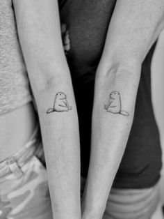 two people with matching tattoos on their arms