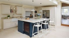 a large kitchen with an island and bar stools