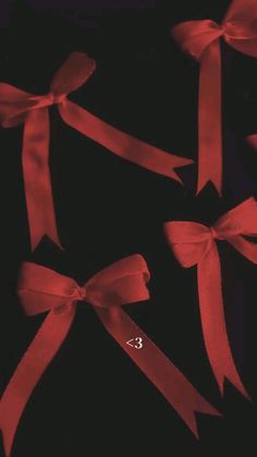 three red bows tied together on a black background