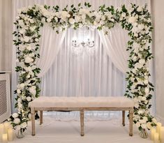 a wedding ceremony setup with white flowers and greenery