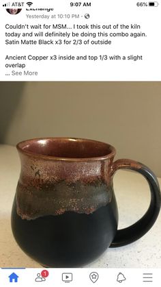 a black and brown mug sitting on top of a table