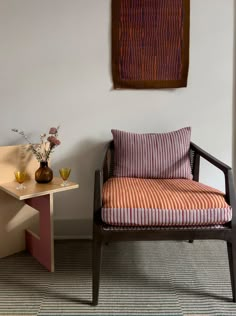 a chair and table in a room with a painting on the wall next to it