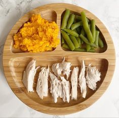 an assortment of food is arranged on a wooden plate with white marble countertop top