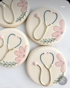 four decorated cookies with flowers and a stethoscope on them