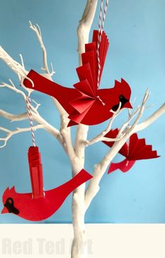 red paper birds hanging from a white tree