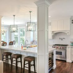 an open concept kitchen and dining room with white cabinets, wood flooring and wooden floors