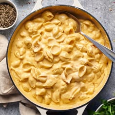 a pot filled with macaroni and cheese on top of a table next to other dishes