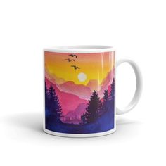 a coffee mug with an image of mountains and birds in the sky at sunset, on a white background