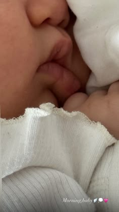 a close up of a baby laying on top of a blanket