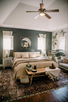 a bed room with a neatly made bed and a ceiling fan