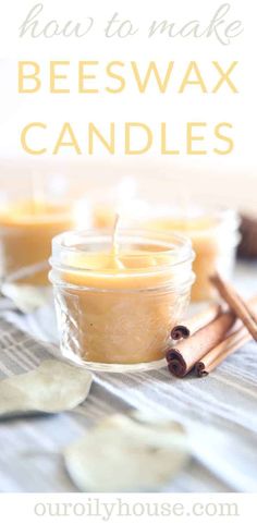 two jars filled with beeswax candles sitting on top of a table next to cinnamon sticks