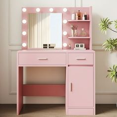 a pink vanity with lights on it and a potted plant