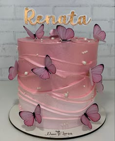 a pink cake decorated with butterflies and the words renata on top