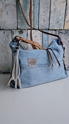 a denim purse with tassels on the handles